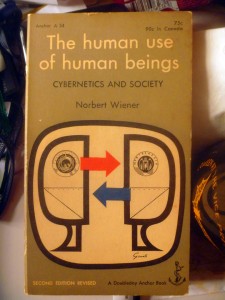 Figure 1: Cover of the 1954 paperback edition of Norbert Wiener's The Human Use of Human Beings, with reciprocating arrows.